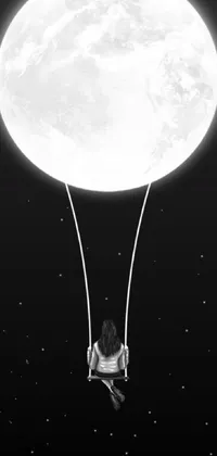 This surreal phone live wallpaper portrays a swing with a full moon in the backdrop