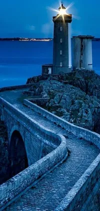 This live wallpaper depicts a majestic lighthouse on top of a rocky cliff overlooking the ocean