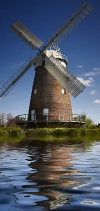Adorn your phone screen with a beautiful live wallpaper of a baroque windmill standing tall above a peaceful body of water