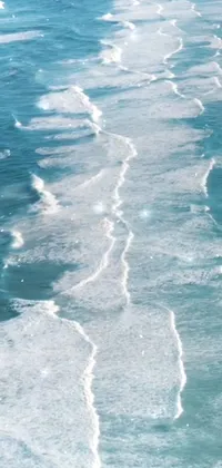 Enjoy a stunning phone live wallpaper of a surfer riding the waves of a beautiful beach