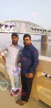 Get a live wallpaper for your phone featuring a charming photograph of two men standing by a bridge with a river behind them