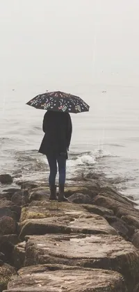 This phone live wallpaper is a beautiful and lonely depiction of a person standing on a pier
