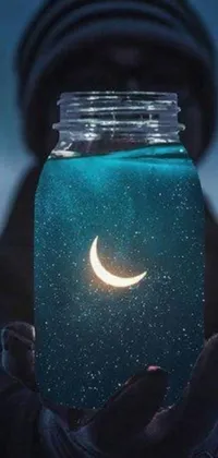 This phone live wallpaper features a magical jar with a crescent in it, set against a soft blue moonlit background