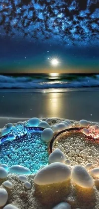 This phone live wallpaper displays a tranquil glass bowl on a sandy beach with the sparkling moonlight backdrop
