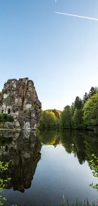 This live wallpaper features a breathtaking body of water nestled amidst lush trees and rocks