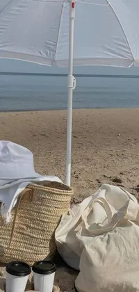 Get in touch with nature with this phone live wallpaper featuring a classic white umbrella on a stunning sandy beach