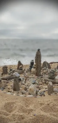 This captivating phone live wallpaper features a digital rendering of a pile of rocks resting on a sandy beach