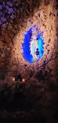 Enhance your smartphone with this captivating live wallpaper that displays a blue light shining through a hole in a stone wall