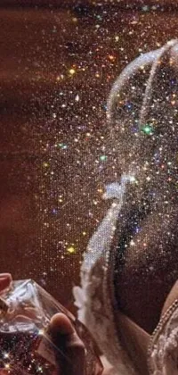 This awe-inspiring phone live wallpaper captures the close-up of a hand holding a smartphone, set against a glittering backdrop of twinkling stars