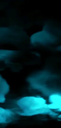 Get mesmerized with this abstract claymation-like live wallpaper for your phone! The image showcases beautiful and blurry clouds against a dark turquoise sky