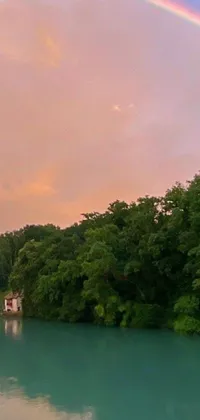 This live wallpaper showcases a mesmerizing landscape with a rainbow in the sky over a waterbody, shot with an iPhone 10