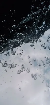 This phone live wallpaper showcases an artistic and unique view of the sky through a plane window, complemented by a microscopic photo and an underwater bubbles background for a calming atmosphere