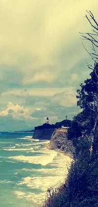 This amazing live wallpaper for your phone depicts a charming lighthouse situated on top of a cliff overlooking the ocean
