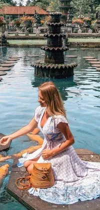 This stunning live wallpaper features a woman feeding koi fish in a tranquil pond surrounded by a magnificent castle in Bali