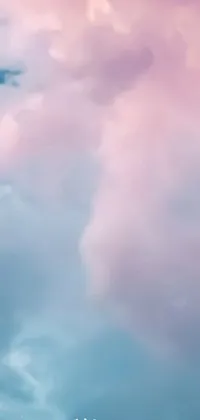 This phone live wallpaper features a beautiful aerial view of a plane flying through a pastel blue sky filled with fluffy, white clouds