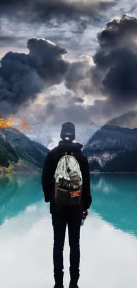 This phone live wallpaper showcases a surreal matte painting of a backpacker overlooking a serene lake