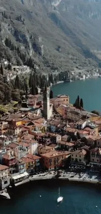 Experience the picturesque scenery of a vibrant town located next to a serene body of water with this stunning live wallpaper
