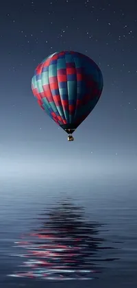 Looking for a stunning mobile wallpaper that will transport you into a world of tranquility and adventure? Check out this breathtaking night sky live wallpaper featuring a hot air balloon hovering over a crystal-clear body of water