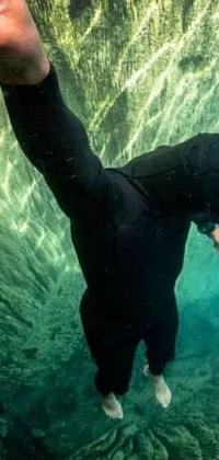 This live phone wallpaper features a wet suit-clad individual engaging in underwater swimming