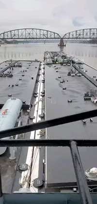 This phone live wallpaper showcases a breathtaking view of a large body of water with a bridge in the backdrop, transmitters on the roof, ships, blurry footage, and an interior room view