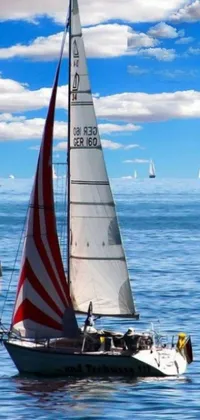 This live wallpaper for your phone features a captivating image of sailboats in action on the open sea, set against a breathtaking backdrop of sparkling blue water and sky