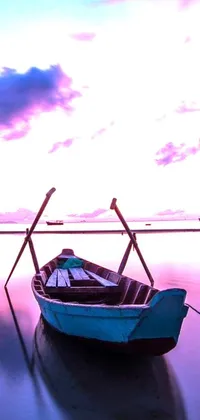This live wallpaper boasts a wooden boat floating peacefully on a serene body of water, all against a mesmerizing backdrop of a purple and blue-hued sky