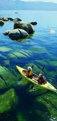 This live wallpaper features a yellow kayak resting on crystal clear waters amidst big rocks and interestingly textured cracks and crevices