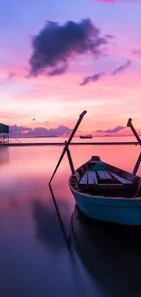 This phone live wallpaper depicts a peaceful beach with a boat poised on its sands, framed by a mesmerizing purple sunset skyline