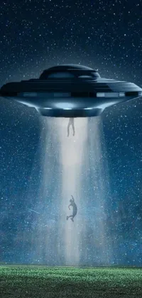 This sci-fi live wallpaper features an otherworldly abduction theme: a man falling from a flying saucer into a field