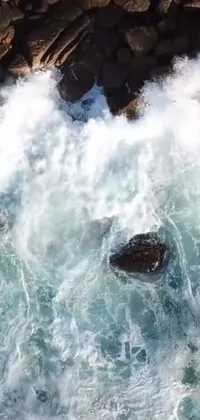 Set your phone apart with this vibrant live wallpaper featuring an exhilarating scene of a skilled surfer riding the crest of a massive wave