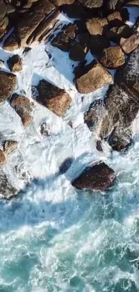 This stunning phone live wallpaper showcases a skilled surfer riding a board on top of crashing waves, captured in cinematic detail
