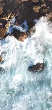 This phone live wallpaper captures the adrenaline-inducing moment of a surfer riding a massive wave
