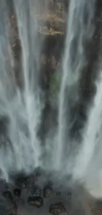 Looking for a stunning live wallpaper for your phone? Check out this nature-inspired design featuring a group of people in front of a beautiful waterfall
