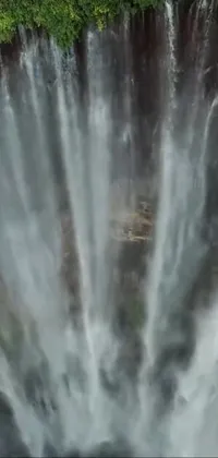 This stunning phone live wallpaper features a breathtaking bird's eye view of a waterfall captured in high definition