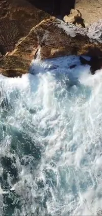 This phone live wallpaper features an exciting scene of a surfer riding a large wave in the ocean