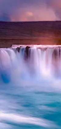 Get lost in the majesty of nature with this stunning phone live wallpaper featuring a cascading waterfall in the middle of a large body of water