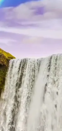 This phone live wallpaper showcases a breathtaking waterfall surrounded by lush greenery