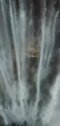 This stunning phone live wallpaper features a beautiful group of people in front of a majestic waterfall