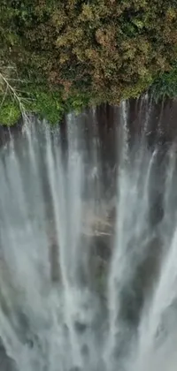 This is a stunning phone live wallpaper featuring a large waterfall set in the middle of a lush forest
