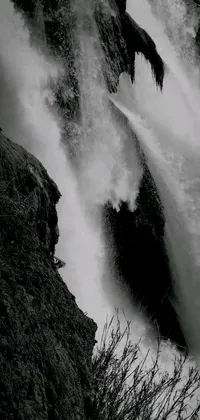This live wallpaper features a stunning black and white photograph of a massive waterfall, capturing the immense power and rugged beauty of nature