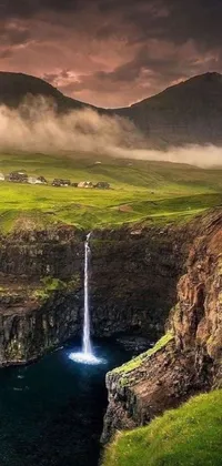 Get mesmerized by the beauty of this phone live wallpaper featuring a stunning waterfall in the green valleys