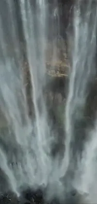 This phone live wallpaper showcases a natural waterfall scenic view surrounded by greenery