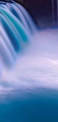 This live phone wallpaper showcases a stunning image of a waterfall in a body of water captured in perfect detail