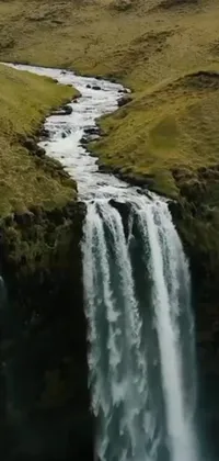 Looking for a stunning live wallpaper for your phone? Look no further than this beautiful waterfall in a grassy field! Captured using hurufiyya techniques, this wallpaper features a unique texture that is sure to captivate your attention
