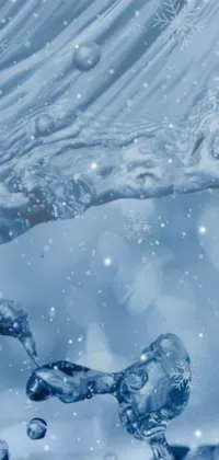 This live phone wallpaper depicts a serene scene of water in motion with snowflakes in the background for a winter wonderland feel