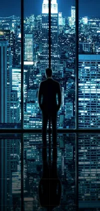 This urban Phone Live Wallpaper showcases a man standing in front of a window that overlooks a city at night
