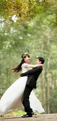 This serene phone live wallpaper showcases a couple in formal wear, dancing in a forest