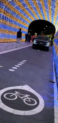 This dynamic phone live wallpaper features an animated scene of a car driving down a street next to a tunnel