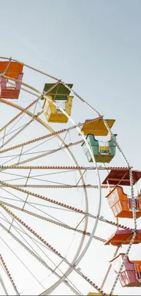 This live wallpaper for your phone features a vintage ferris wheel against a stunning blue sky