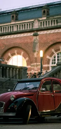 The live phone wallpaper depicts two vintage cars parked in front of an antique building